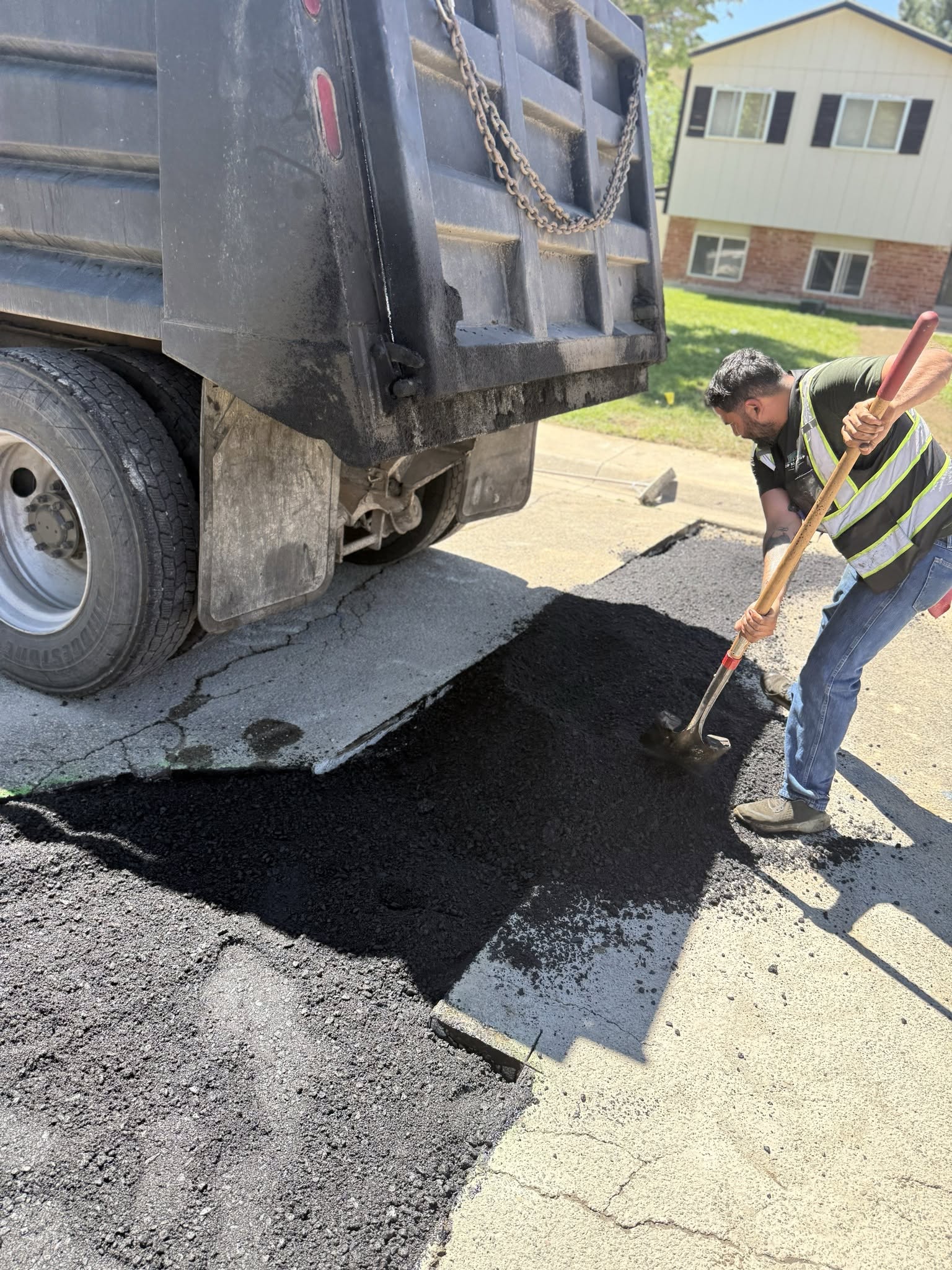 JP Blacktop crew hand-laying asphalt from a dump truck