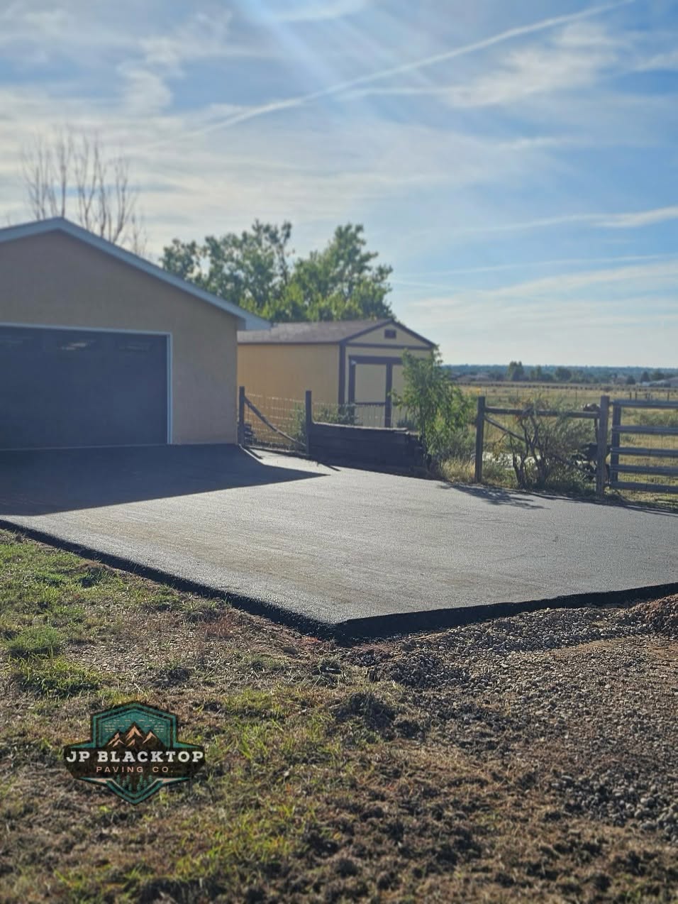 New residential asphalt driveway leading to a garage