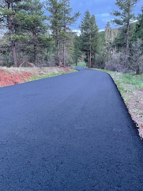 Freshly paved private road winding through the Colorado mountains